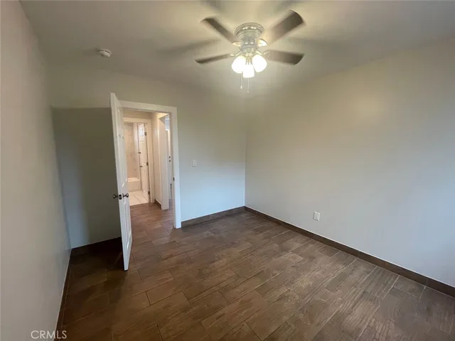 an empty room with a ceiling fan and a bathroom