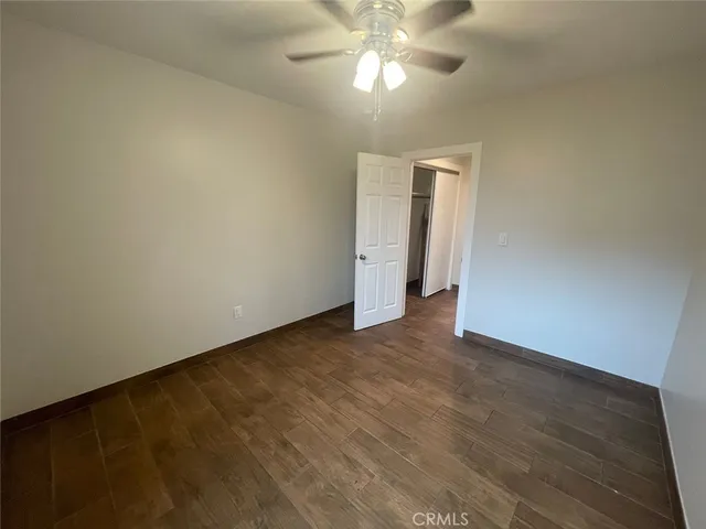 a view of an empty room with a chandelier fan