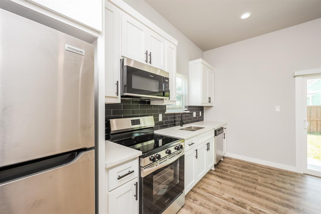 2025 Stuart Street, Unit A Greenville, TX 75401 - Photo 3 of 11 a kitchen with a stove microwave and sink