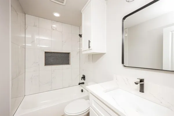 a bathroom with a sink a toilet and bathtub