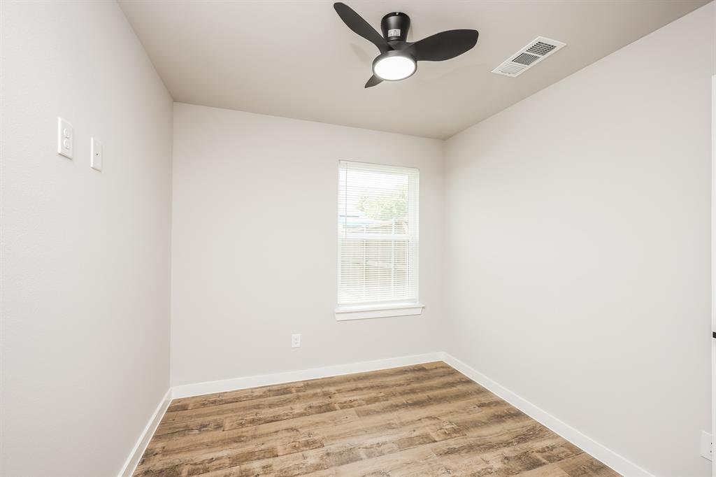 2025 Stuart Street, Unit A Greenville, TX 75401 - Photo 5 of 11 an empty room with a window and ceiling fan