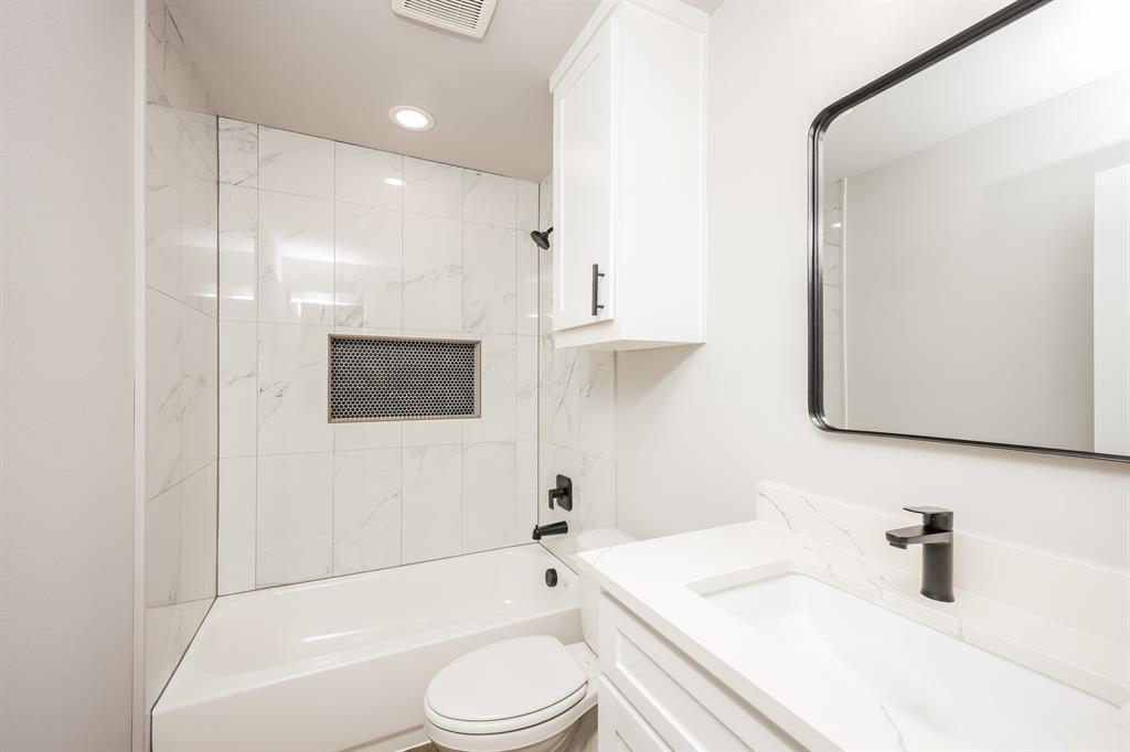 2025 Stuart Street, Unit A Greenville, TX 75401 - Photo 7 of 11 a bathroom with a sink a toilet and shower