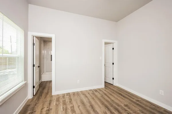 a view of a room with wooden floor and a bathroom