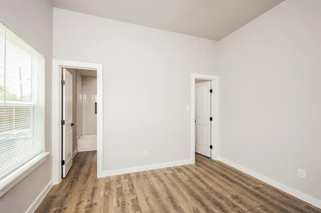 a view of a room with wooden floor and a bathroom