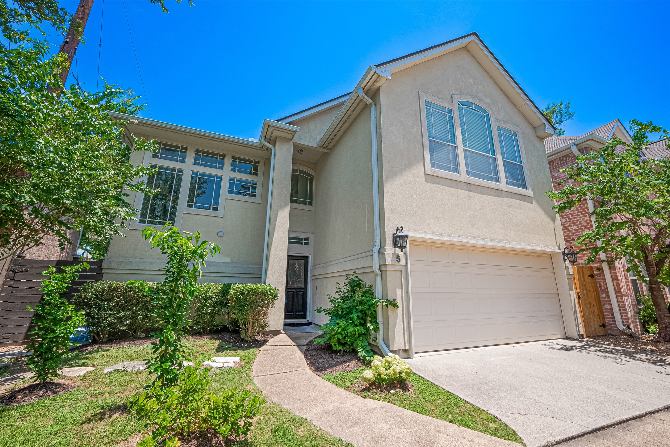 1413 Whispering Pines Drive, Unit 5 Houston, TX 77055 - Photo 4 of 47 a front view of a house with a yard and garage
