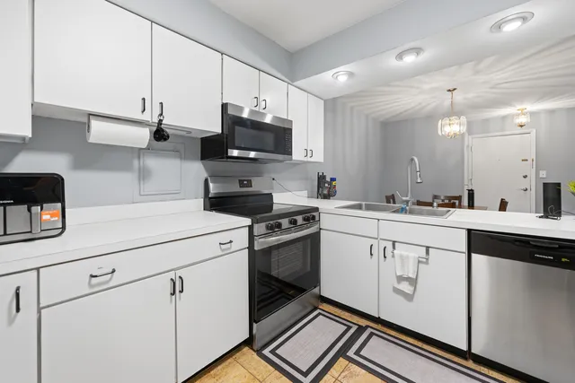 a kitchen with white cabinets and appliances