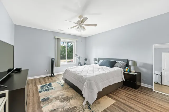a bedroom with a bed and wooden floor