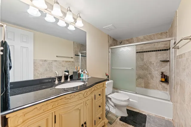 a bathroom with a sink a toilet and a large mirror