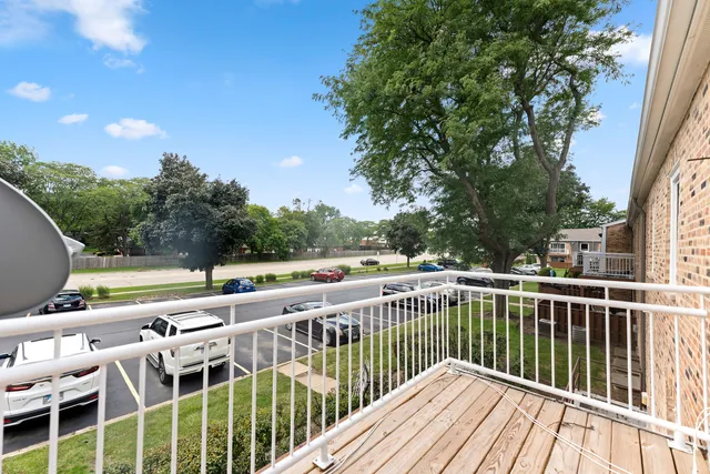 a view of a roof deck with couches and wooden fence