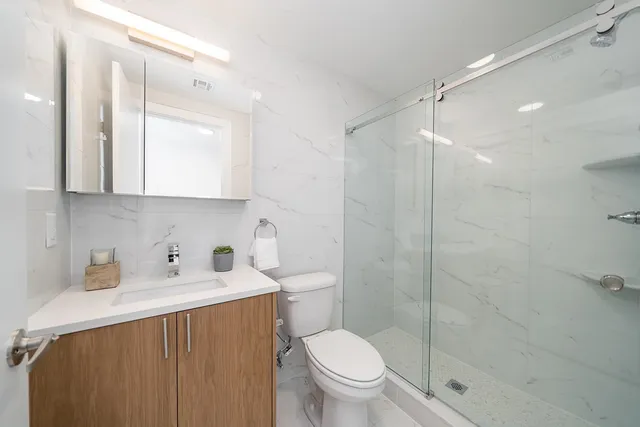 a bathroom with a sink a toilet and shower