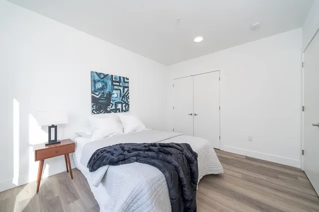 a bedroom with a bed and a painting on the wall