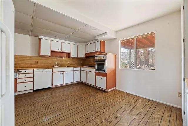 a kitchen with granite countertop white cabinets and white appliances