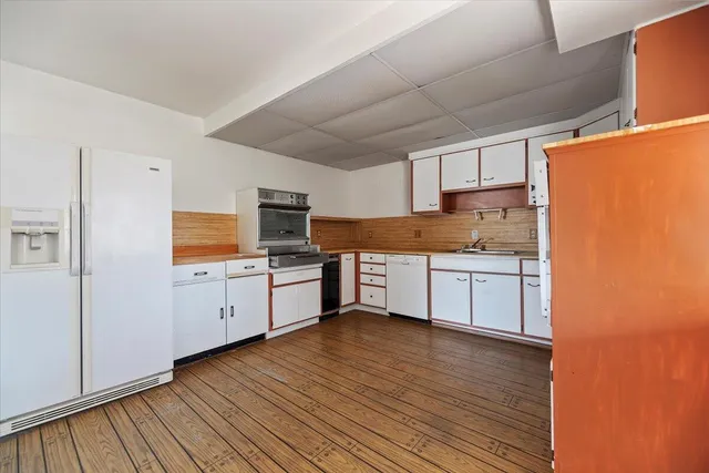 a kitchen with stainless steel appliances granite countertop a stove a sink and white cabinets