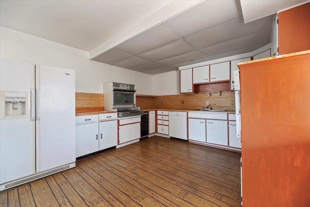 61313 El Coyote Lane Joshua Tree, CA 92252 - Photo 23 of 48 a kitchen with granite countertop white cabinets and white appliances