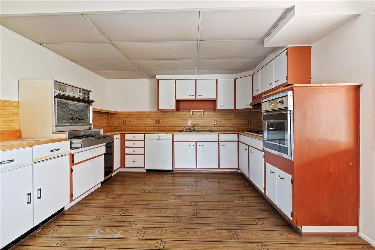 61313 El Coyote Lane Joshua Tree, CA 92252 - Photo 24 of 48 a kitchen with stainless steel appliances granite countertop a stove a sink and white cabinets