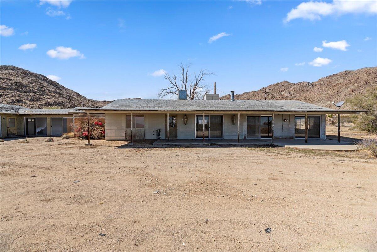 61313 El Coyote Lane Joshua Tree, CA 92252 - Photo 5 of 48 a front view of a house with a yard and balcony