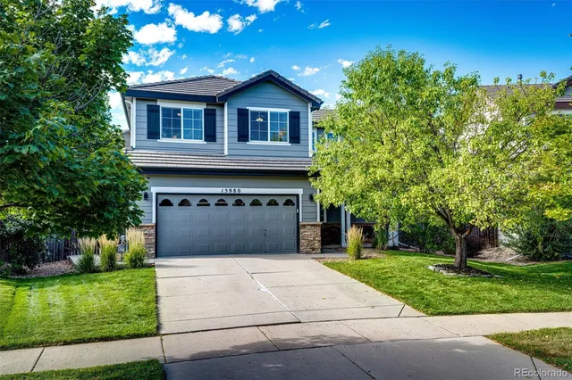 a front view of a house with a yard and trees
