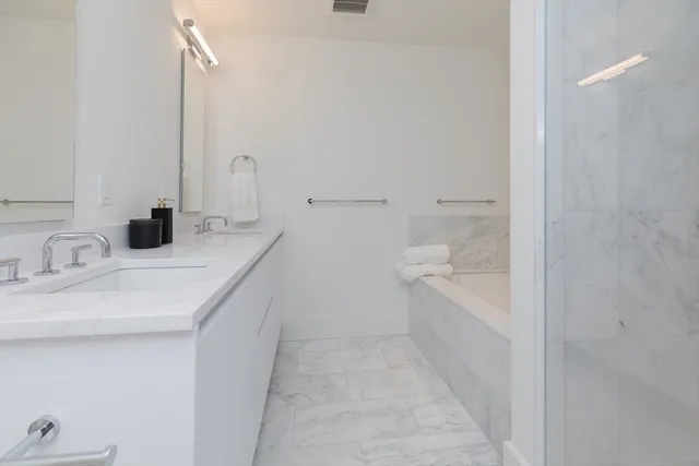 a bathroom with a tub sink and mirror