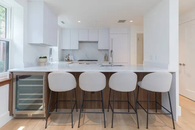 a kitchen with granite countertop a dining table chairs and cabinets