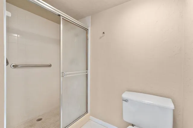 a white toilet sitting next to a shower