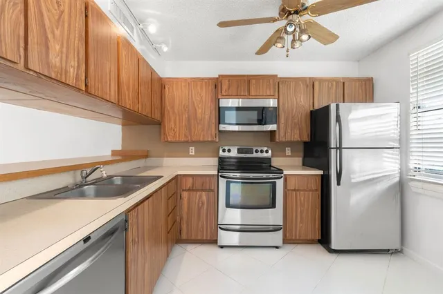 a kitchen with stainless steel appliances a refrigerator sink and microwave