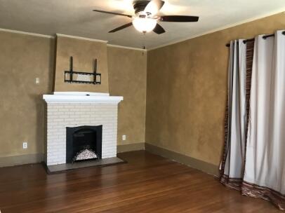 2311 16th Street Lubbock, TX 79401 - Photo 15 of 30 a view of an empty room with wooden floor fireplace and a window