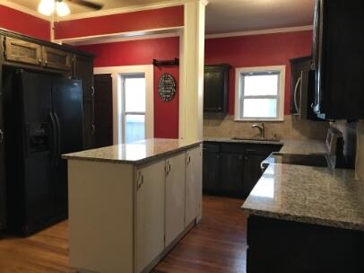 2311 16th Street Lubbock, TX 79401 - Photo 6 of 30 a kitchen with kitchen island granite countertop a sink and a refrigerator