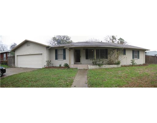 a front view of house with a garden and patio