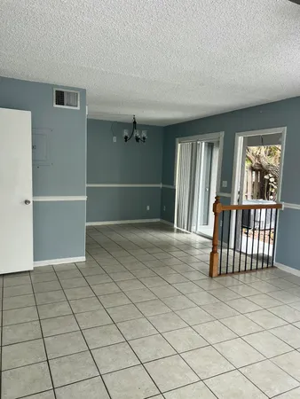 an empty room with staircase and windows