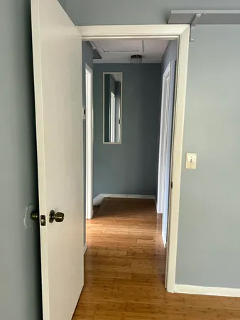 a view of a hallway with wooden floor