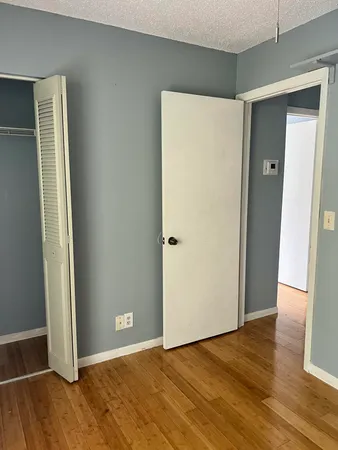 an empty room with wooden floor and closet