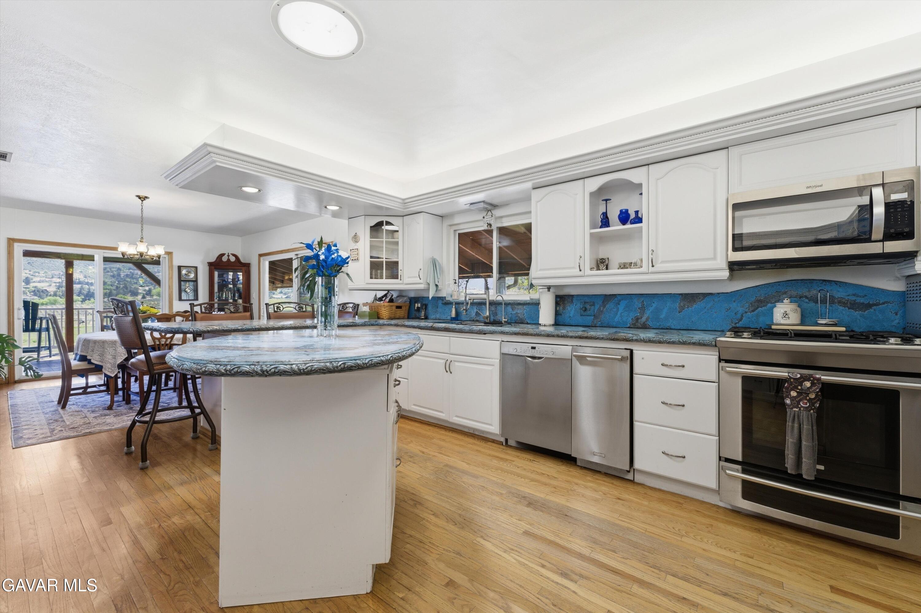 9065 Elizabeth Lake Road Leona Valley, CA 93551 - Photo 20 of 58 a kitchen with a sink cabinets and wooden floor