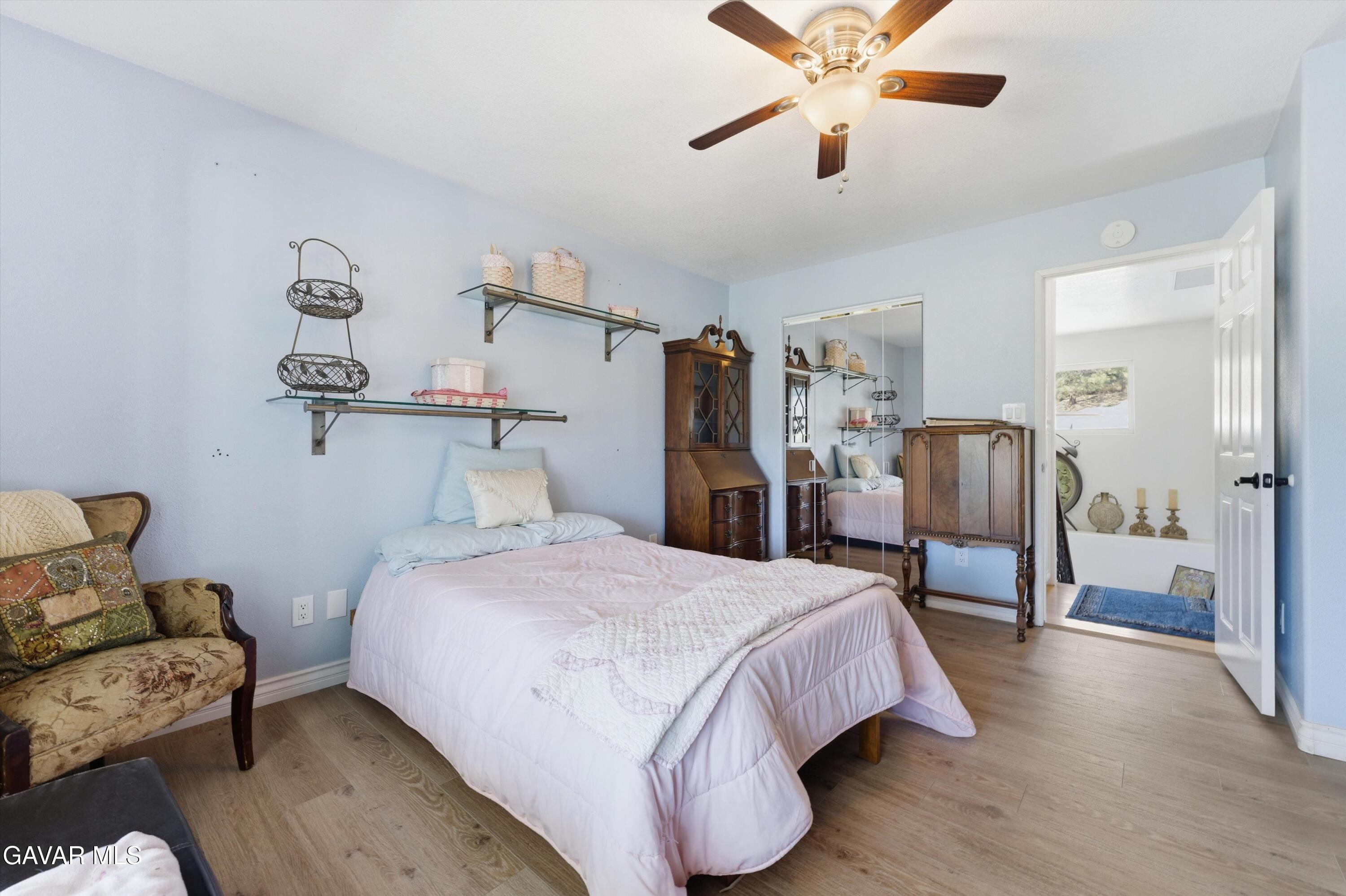 9065 Elizabeth Lake Road Leona Valley, CA 93551 - Photo 33 of 58 a bedroom with a bed couch and a ceiling fan