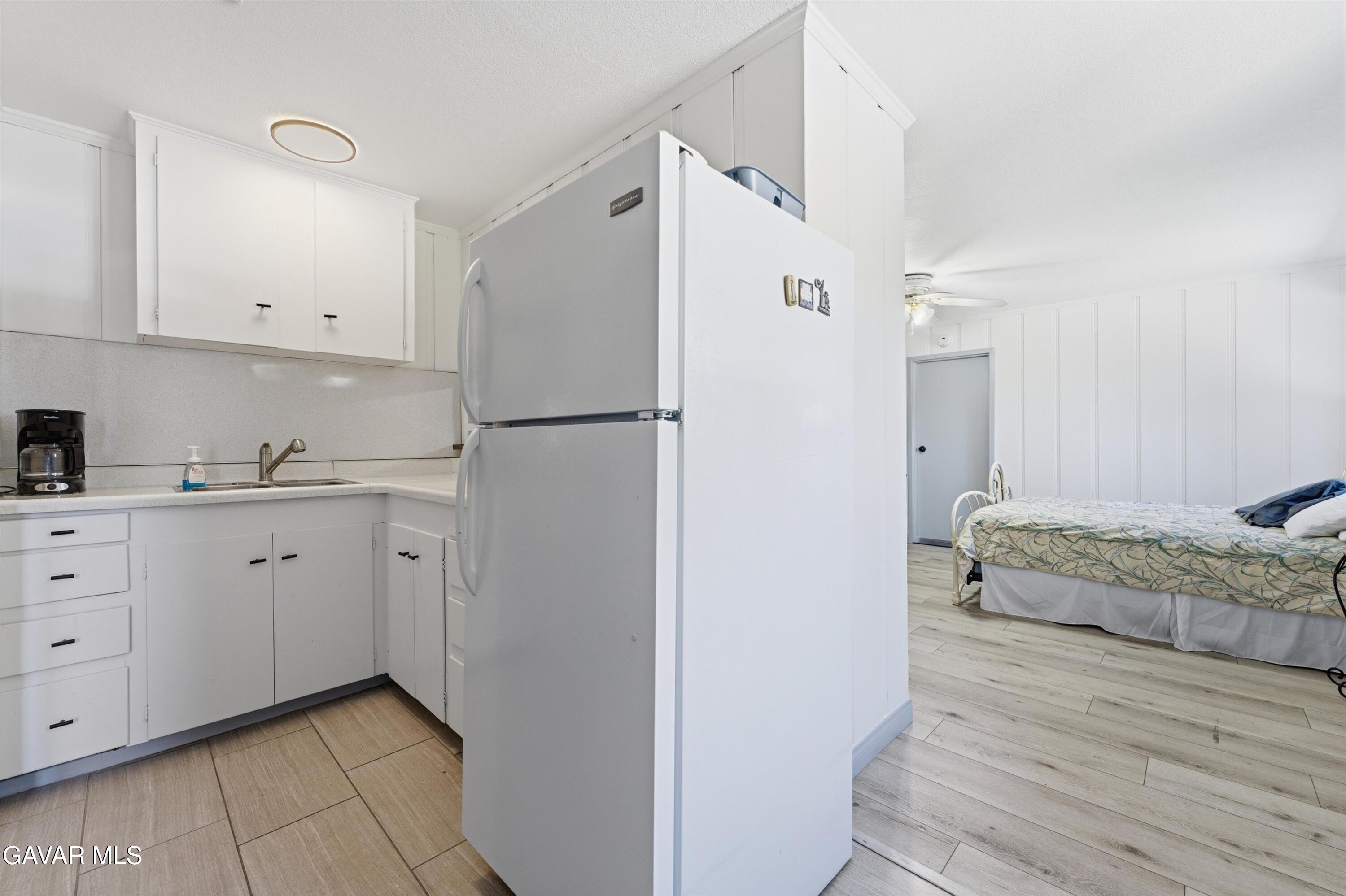9065 Elizabeth Lake Road Leona Valley, CA 93551 - Photo 47 of 58 a kitchen with a refrigerator and white cabinets