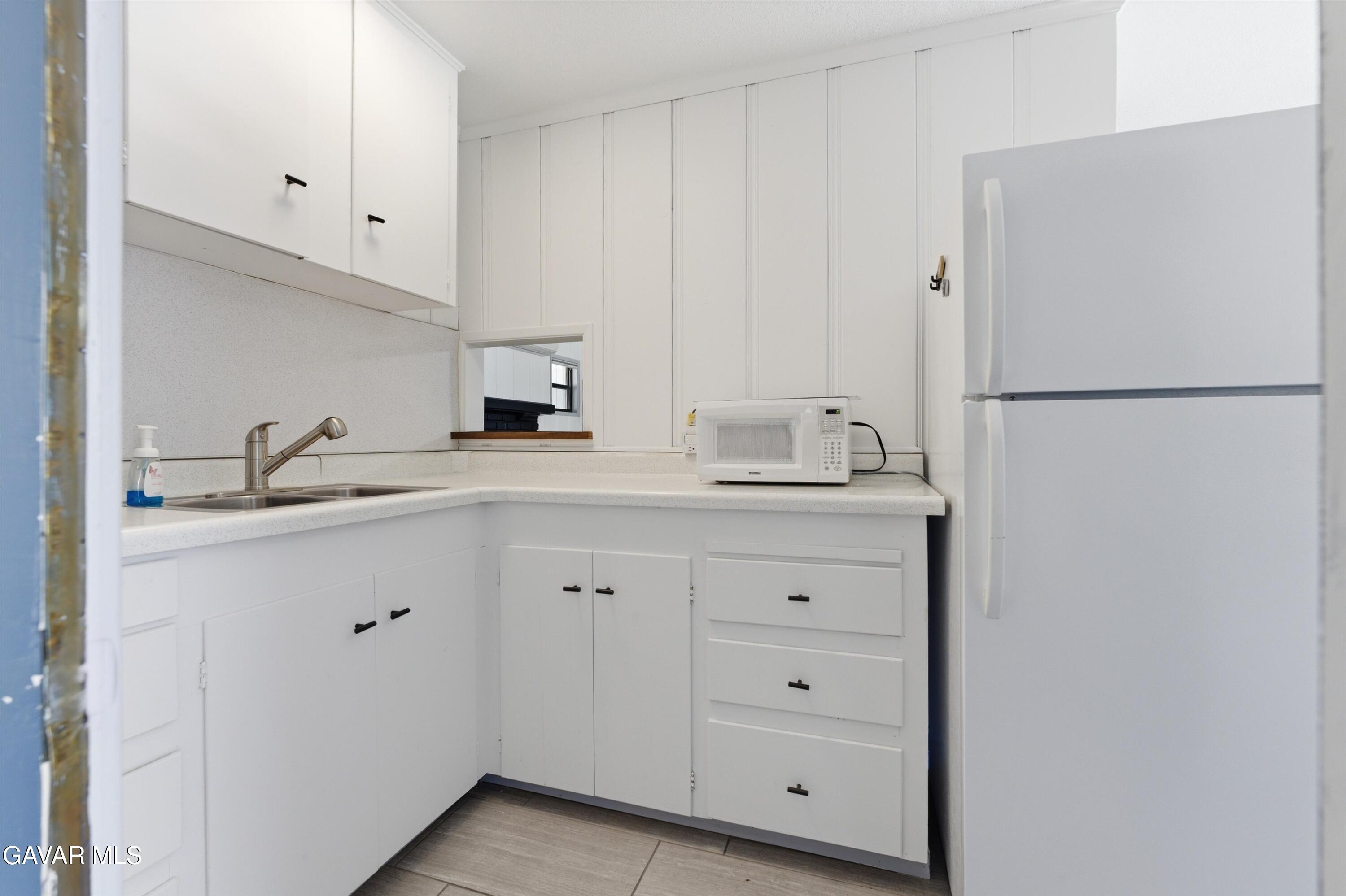 9065 Elizabeth Lake Road Leona Valley, CA 93551 - Photo 49 of 58 a kitchen with white cabinets and refrigerator