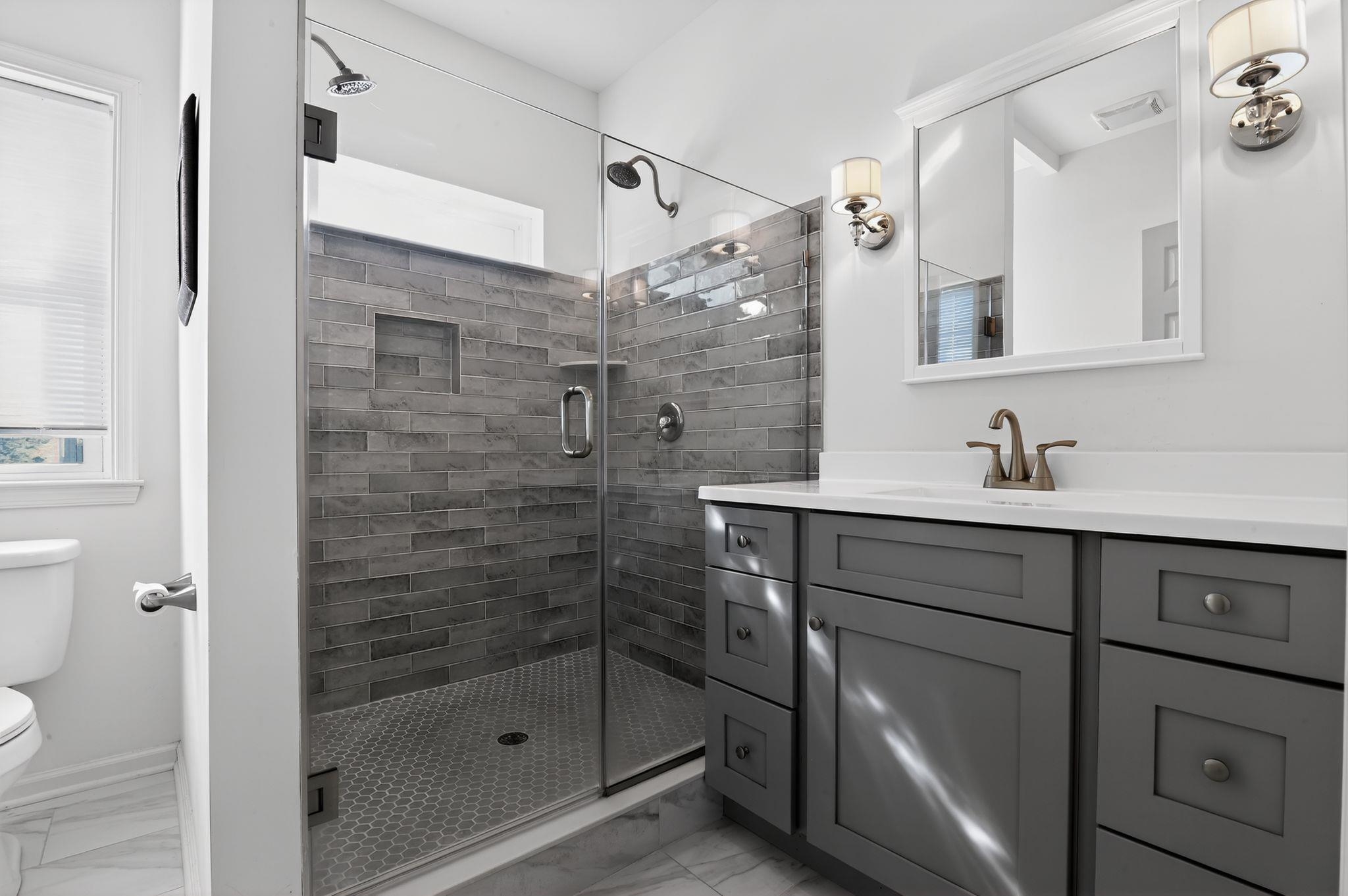 5 East Sumner Avenue Strathmere, NJ 08248 - Photo 13 of 35 a bathroom with a shower sink and mirror