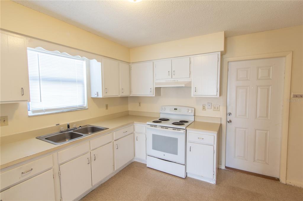 709 Mosley Road Lake Alfred, FL 33850 - Photo 6 of 17 a kitchen with cabinets appliances a sink and a window