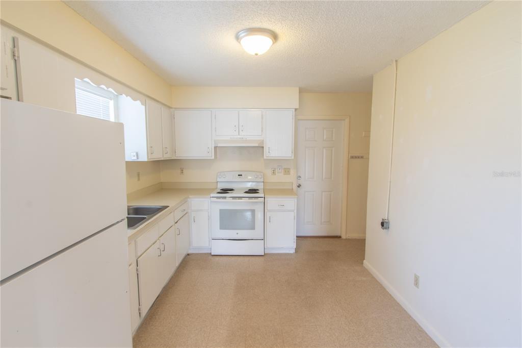 709 Mosley Road Lake Alfred, FL 33850 - Photo 8 of 17 a kitchen with granite countertop white cabinets and white appliances