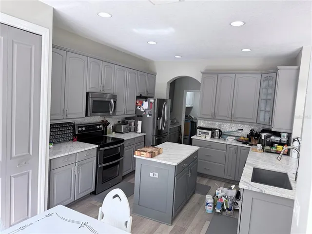 a kitchen with a sink stove and wooden floor
