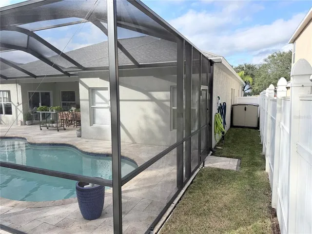 a view of a patio with a table and chairs and a barbeque