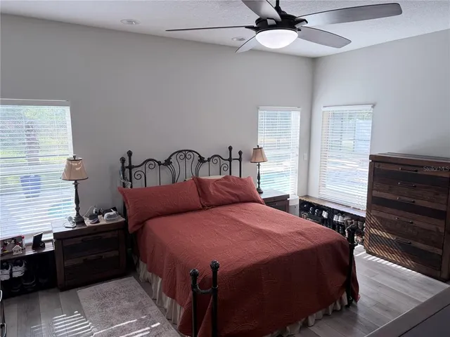 a bedroom with a bed and wooden floor