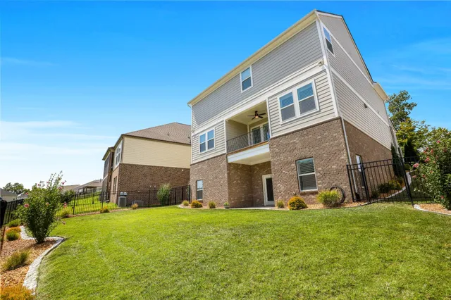 a view of a house with backyard and a tree