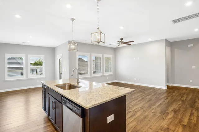 a kitchen with granite countertop a sink and a wooden floor