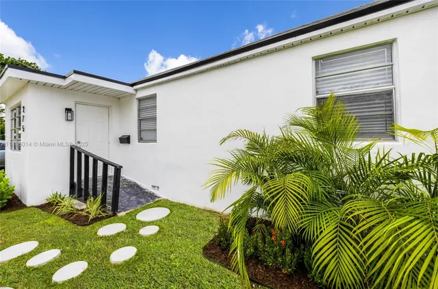 a view of an house with backyard and patio