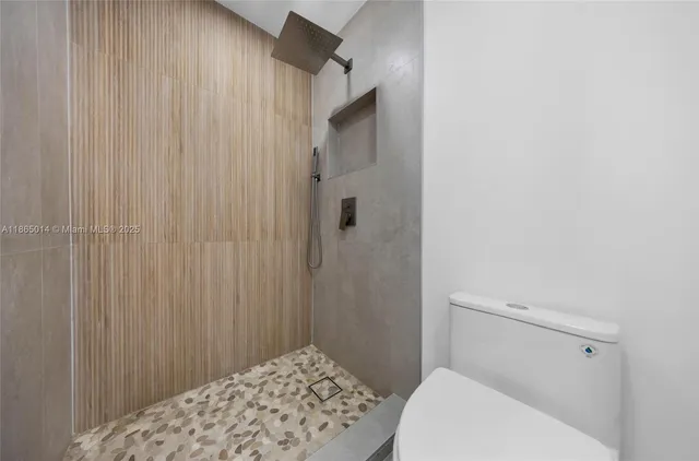 a bathroom with a toilet and a shower curtain
