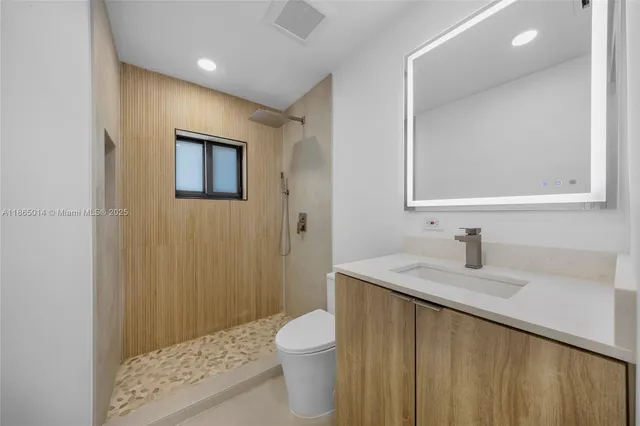 a bathroom with a sink a toilet and shower