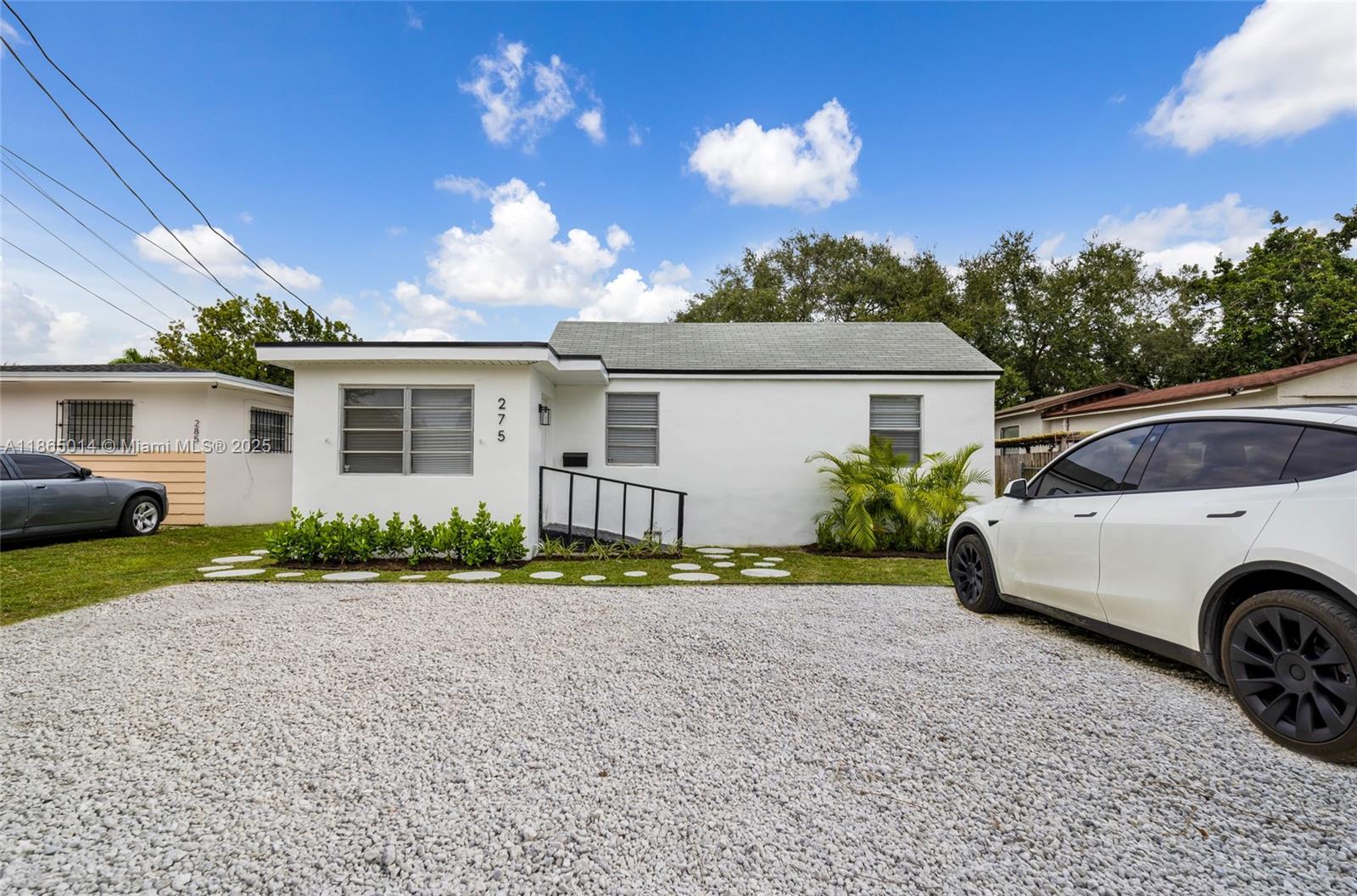 275 Northwest 97th Street Miami, FL 33150 - Photo 3 of 26 a front view of a house with a yard and garage