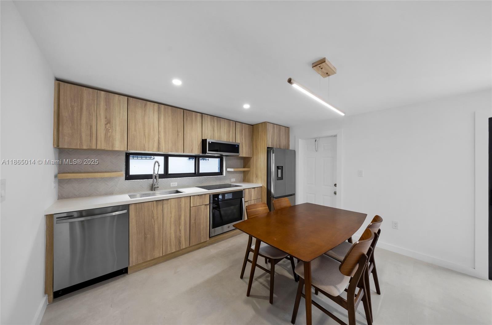 275 Northwest 97th Street Miami, FL 33150 - Photo 5 of 26 a kitchen with stainless steel appliances granite countertop a stove a sink dishwasher a microwave oven with a dining table and chairs