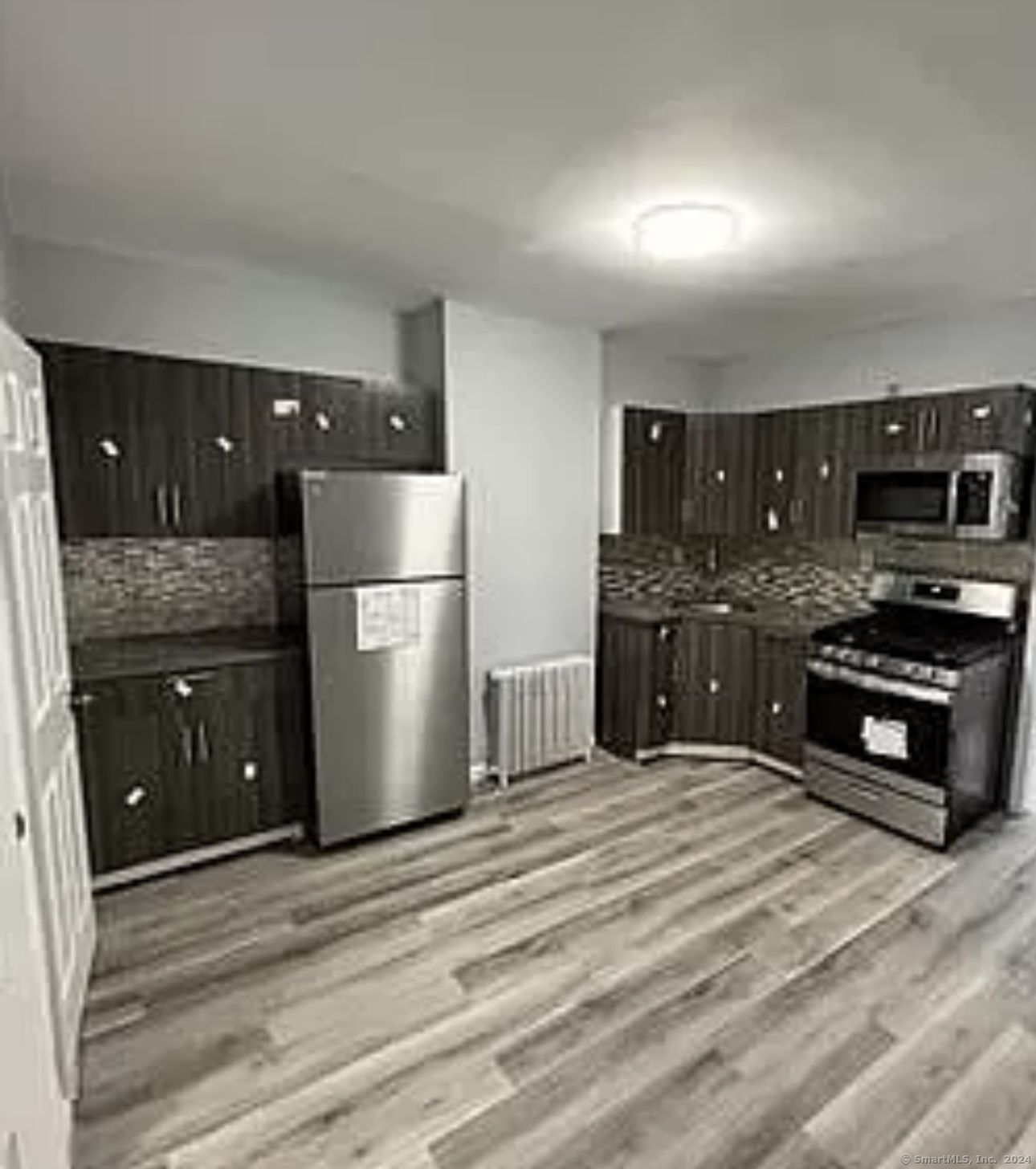 a kitchen with stainless steel appliances granite countertop a refrigerator and a stove top oven