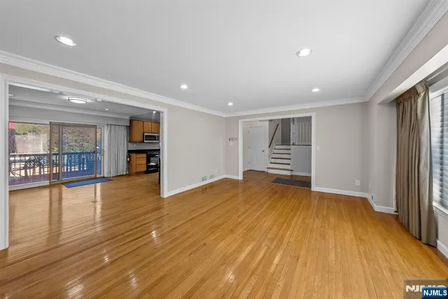 a view of empty room with wooden floor and window